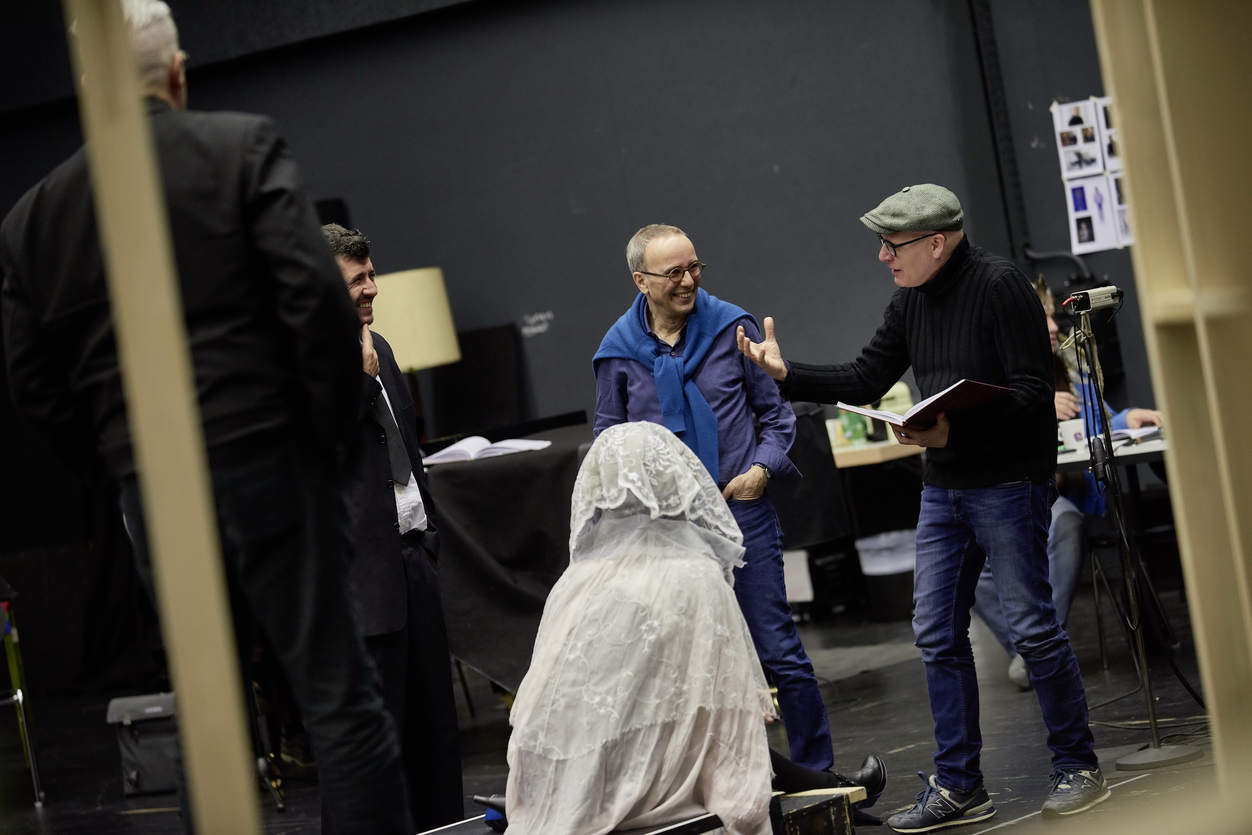 Jossi Wieler (links) bei der Probe zur Neuproduktion der Oper „Don Pasquale“ von Gaetano Donizetti im Gespräch mit dem Chefdramaturgen und Co-Regisseur Sergio Morabito (rechts) sowie Mitwirkenden der Produktion.